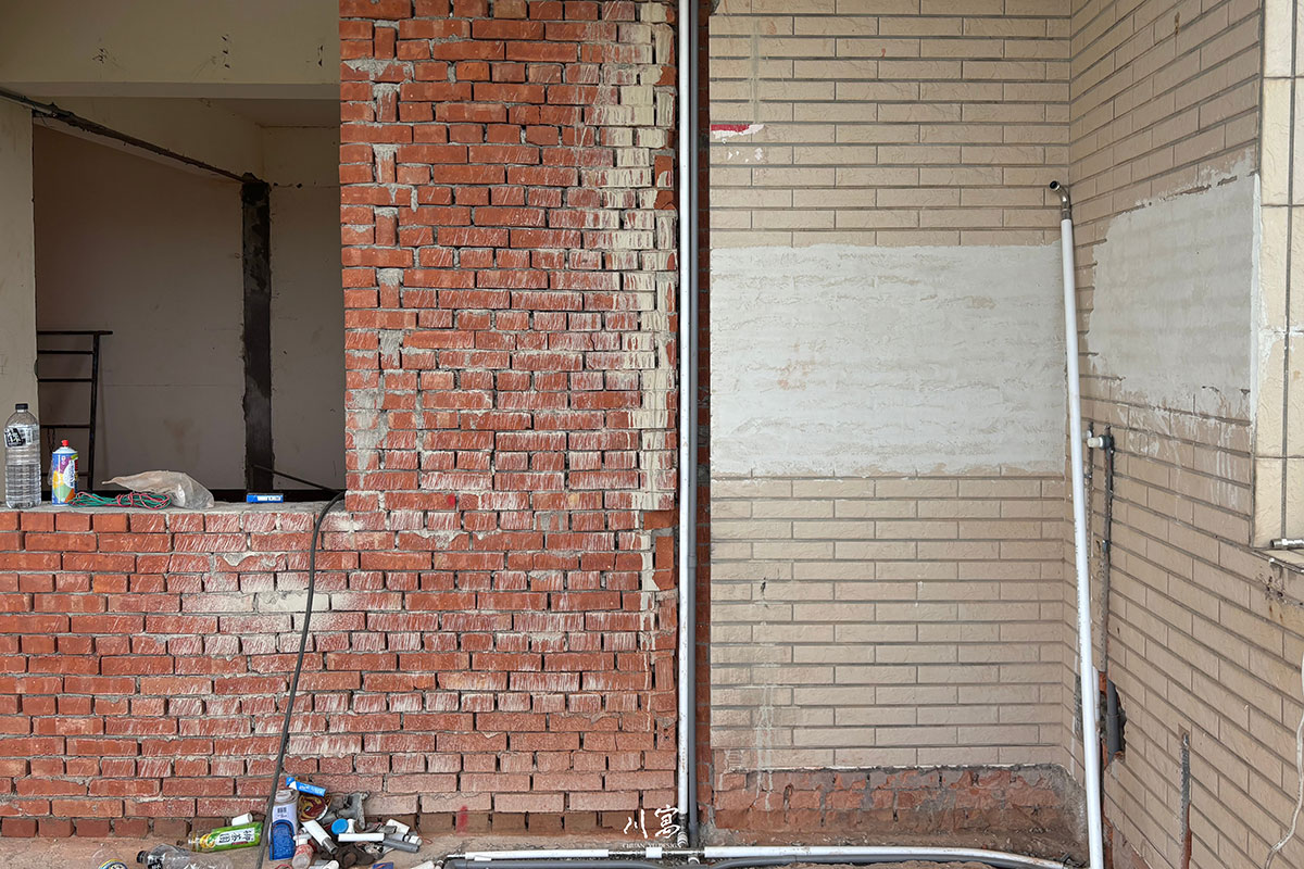 老屋翻新拆除工程現場，牆面移除後露出原始紅磚結構，展現老宅改造的初始階段。